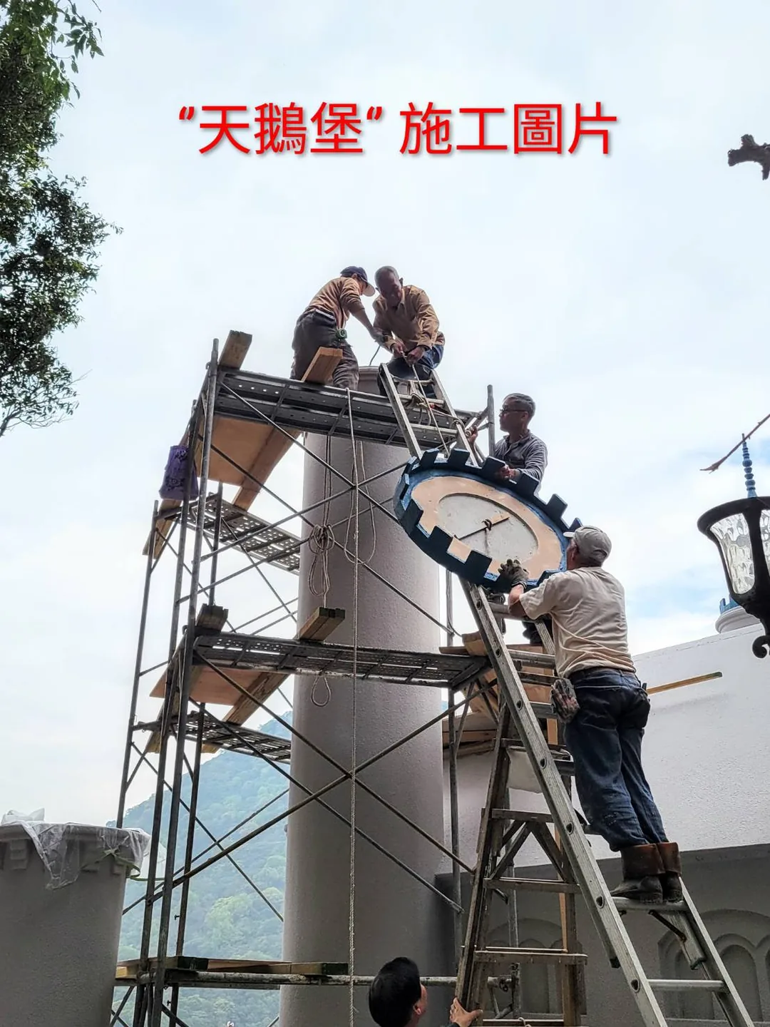 天鵝堡施工現場，多位師傅在塔頂鷹架上合力安裝圓形塔冠構件