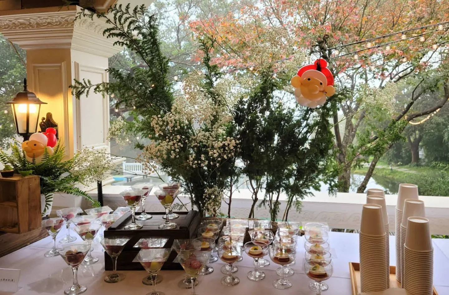 甜點檯 真愛桃花源餐廳甜點檯,杯裝甜點與飲品排列於窗邊長桌,窗外為園區湖景與落羽松(照片攝於節慶佈置期間)